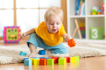 child toddler playing wooden toys at home - obrazy, fototapety, plakaty