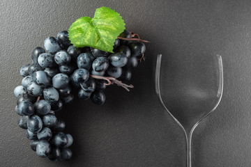 Wine glass made of forks and grape on black