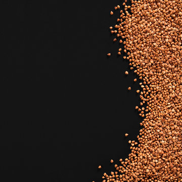 sprinkled  premium buckwheat groats on black background