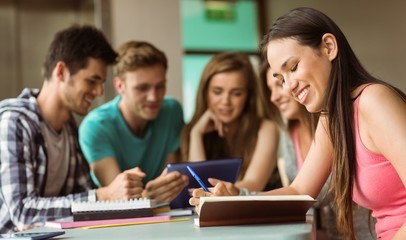 Smiling friends sitting studying and using tablet pc
