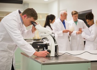 Obraz premium Young medical student working with microscope