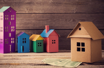 A paper houses stands over a wooden background