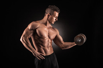 Fototapeta na wymiar Muscular man with dumbbells on black background