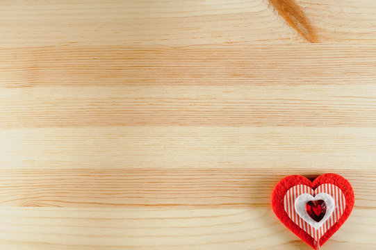 The heart of felt on wooden background