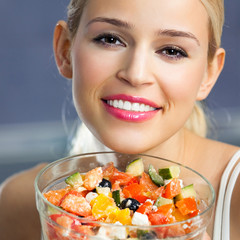 Cheerful smiling woman eating salad