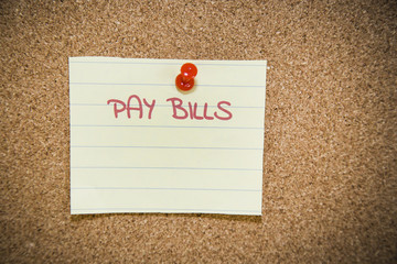 Pay bills note on a bulletin board