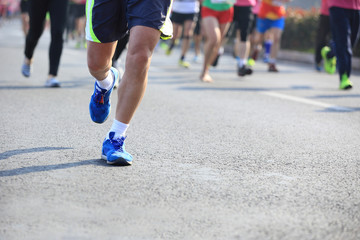 marathon athletes legs running on city road