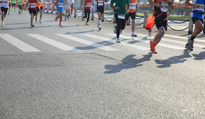 marathon athletes legs running on city road