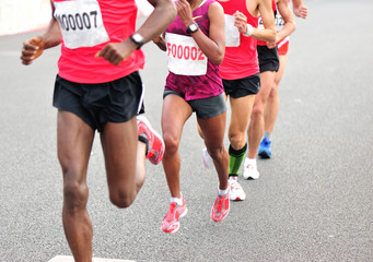 Fototapeta premium marathon athletes legs running on city road