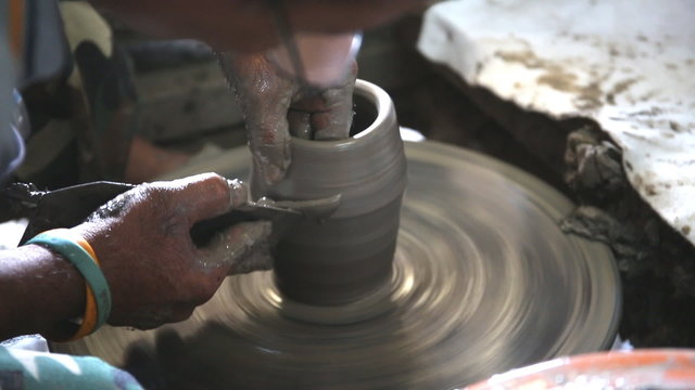 Close up of hands working clay on potter's wheel