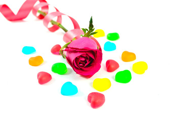 red rose with colorful heart shape jelly candy on white backgrou