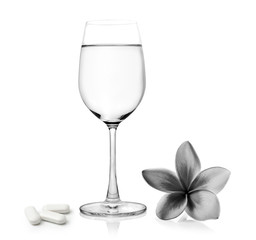 Glass of water pills and Tropical flowers frangipani