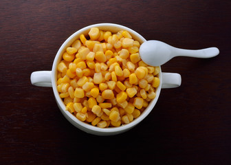 corn in bowl isolated on wooden background