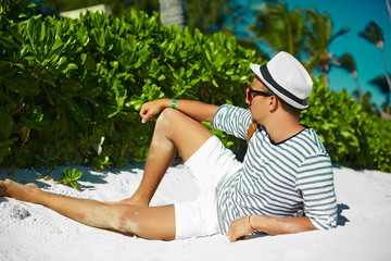 Stylish man model lying on beach sand