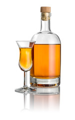 Flasche und hohes Kelchglas mit bernsteinfarbener Flüssigkeit