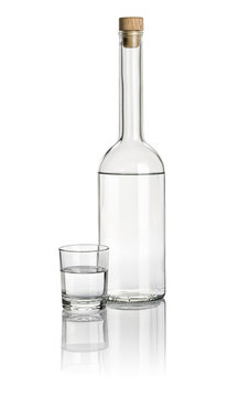 Spirituosenflasche und Trinkglas gefüllt mit klarer Flüssigkeit