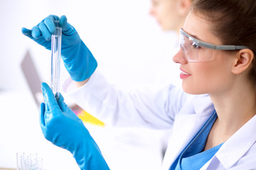 Woman researcher is surrounded by medical vials and flasks,