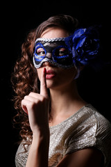 Obraz premium Beautiful girl with masquerade mask on dark background