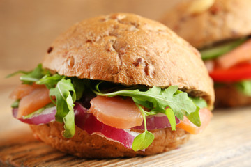 Sandwiches with salmon on wooden background