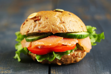 Sandwich with salmon on wooden background