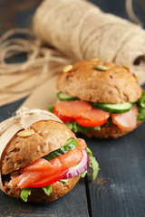 Sandwiches with salmon and vegetables on wooden background