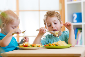kids eating healthy food in kindergarten or nursery