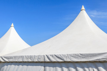 Top of white canvas tent with clear blue sky background