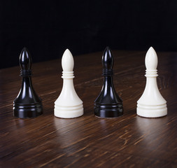 White and black chess officers on wood table.