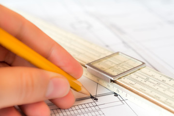 Hand holds the pencil to create a drawing. Angle view