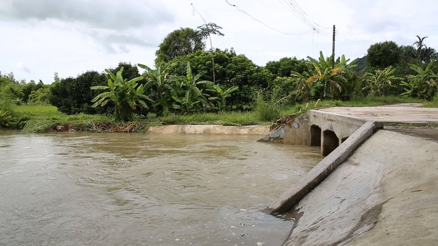 Raging River Floodwater Under a Bridge .