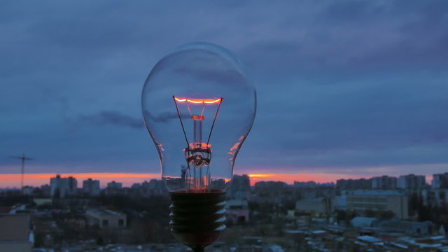 The incandescence bulb  by the industrial city background