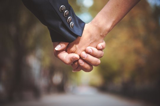 couple holding hand together in park