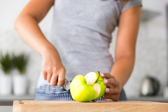 Unrecognizable Woman Slicing Apple In Kitchen