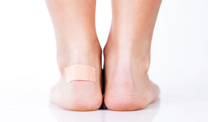 Closeup of woman's heel with blister plaster on - obrazy, fototapety, plakaty