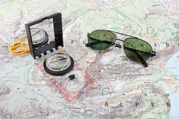 Compass and pilot sunglasses on a hiking map