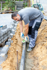 Worker puts border stones.