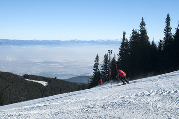 Ski slope with skiers on background of mountain landscape