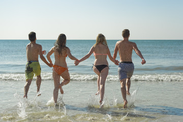Jugendliche laufen in Wasser Nordsee