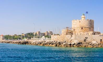 Fototapeta na wymiar Old fortress with lighthouse in the port of Mandraki. Rhodes Isl