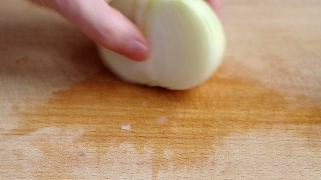 Man slicing onion on wooden board