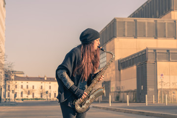 Beautiful young woman playing tenor saxophone - obrazy, fototapety, plakaty