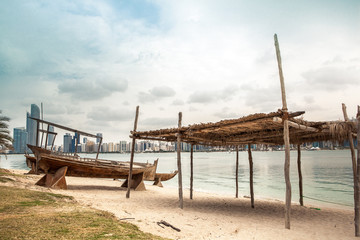sea beach with old wooden boath and luxury skyscarper
