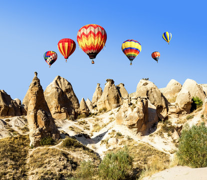 Balloons over the volcanic mountain landscape of Cappadocia