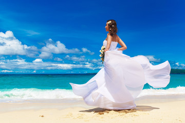 Fototapeta na wymiar Beautiful brunette bride in white wedding dress with big long wh