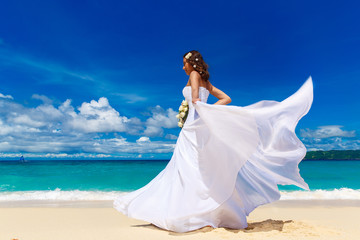 Fototapeta na wymiar Beautiful brunette bride in white wedding dress with big long wh