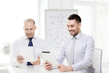 Fototapeta premium two smiling businessmen with tablet pc in office