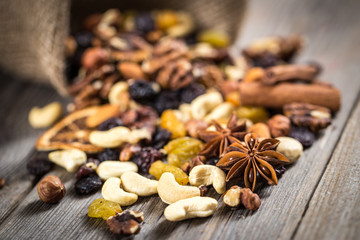 Close-up of nuts and dried fruits mix on wooden surface.