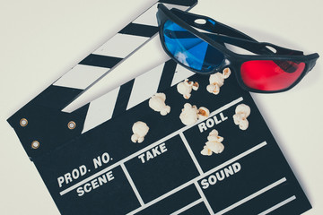 Clapboard with 3d glasses and popcorn.