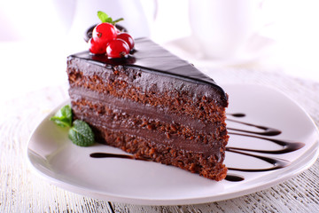 Delicious chocolate cake on plate on table on light background