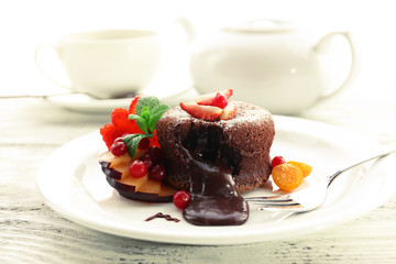 Hot chocolate pudding with fondant centre with fruits, close-up